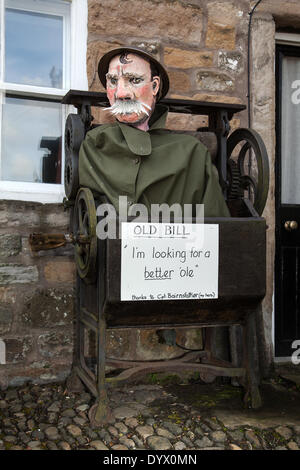 Whiskered 'Old Bill' in a mangle at the Wray Scarecrow Festival which opened on Saturday 26th April, 2014 for a series of Scarecrow parades, Old Bill is a fictional character created in 1914–15 by cartoonist Bruce Bairnsfather. Old Bill (police officer0 was depicted as an elderly, pipe-smoking British 'tommy' with a walrus moustache. The character achieved a great deal of popularity during World War I where it was considered a major morale booster for the British troops. Stock Photo