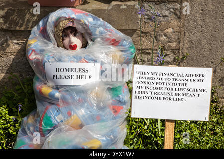 Ill informed and badly advised Homless 'Skint' Investor wrapped in plastic at the Wray Scarecrow Festival, established 1995, takes place every year, with a different theme in the week leading up to May Day. Villagers put up 'Hero's & Villains' scarecrows outside their homes this year. Stock Photo