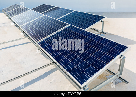 Solar panels standing on a rooftop under a bright sunny day Stock Photo