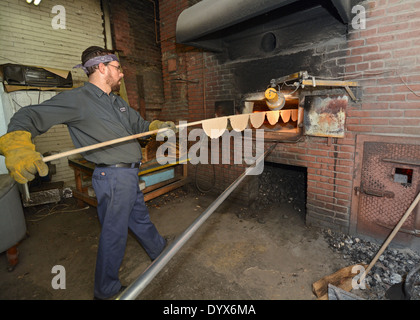 A religious Jewish man in a Matzoh bakery putting Matzoh onto an oven. Stock Photo