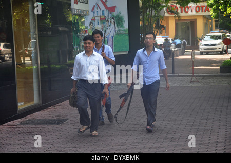 Three Vietnamese men carrying rifles walk in central Hanoi, Vietnam Stock Photo
