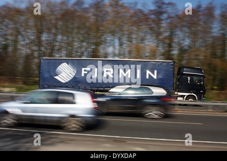 An Alan Firmin truck traveling along the A12 dual carriageway in Essex, England - two cars travel in the opposite direction Stock Photo