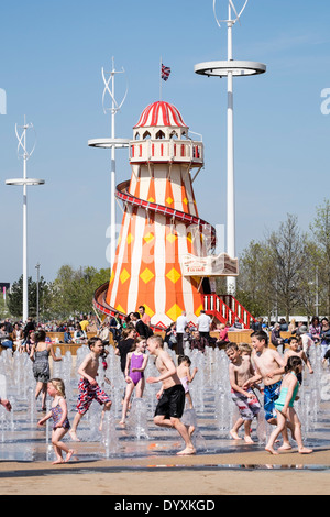 Helter Skelter funfair and fountain with many visitors at Queen Elizabeth Olympic Park in Stratford London United Kingdom Stock Photo