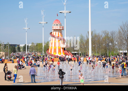 Helter Skelter funfair and fountain with many visitors at Queen Elizabeth Olympic Park in Stratford London United Kingdom Stock Photo