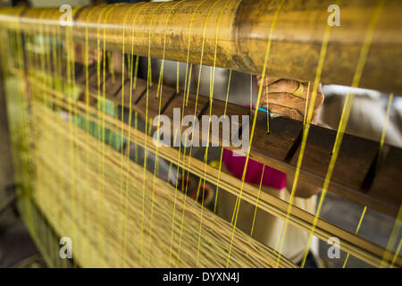 April 25, 2014 - Mae Chan, Chiang Rai, Thailand - A woman weaves papyrus reed mats by hand at her family home in Mae Chan, Chiang Rai province, Thailand. Families in Chiang Rai province still make woven reed mats by hand. The mats are used around the house as an impromptu table, and farmers as something to spread out on the ground during lunch, like a picnic blanket. Some families use them as mattresses to sleep on. They cost anywhere from 15Baht (.50Â¢ US) to 150Baht ($5.00 US) depending on size. (Credit Image: © Jack Kurtz/ZUMAPRESS.com) Stock Photo