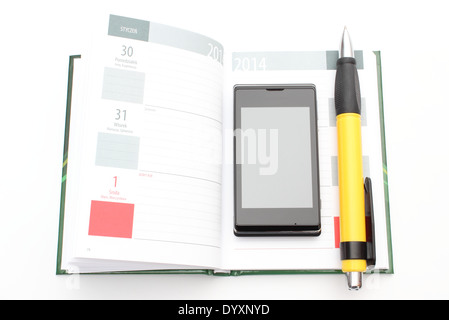 Modern mobile phone and big yellow pen lying on open calendar. Isolated on white background Stock Photo