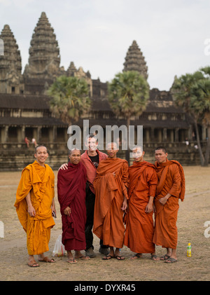 Western tourist with Buddhist monks in traditional robes at Angkor Wat, Siem Reap, Cambodia Stock Photo