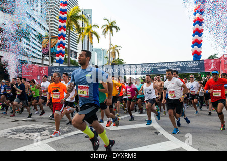 Male runners sprinting away from crowded starting line of 2014 Mercedes-Benz Corporate Run in Miami, Florida, USA. Stock Photo