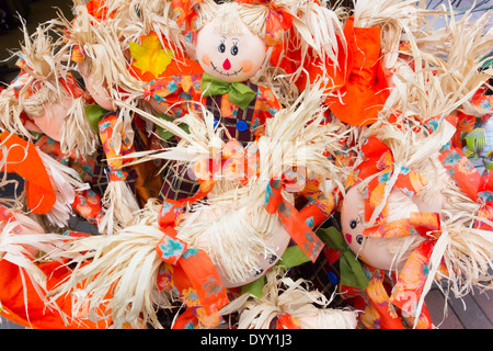 A display of toy rag doll garden ornaments made from straw and bright orange cloth Stock Photo