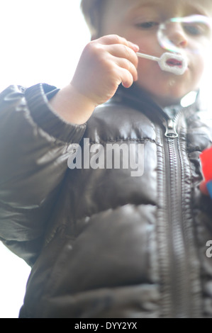 3 year old boy blowing bubbles Stock Photo