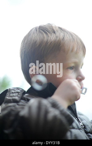 3 year old boy blowing bubbles Stock Photo