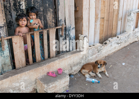 Xingu River, Altamira port, Para State, Brazil. Boatbuilders home, two young children, dog, flip-flops. Stock Photo