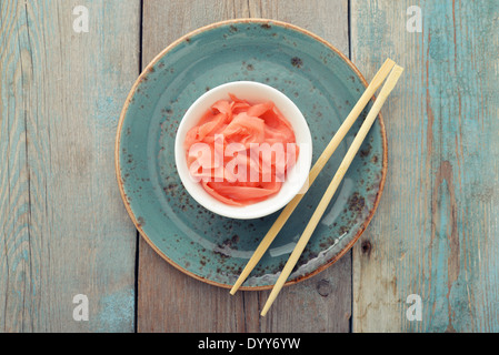 Pickled ginger with wooden chopsticks on plate top view Stock Photo