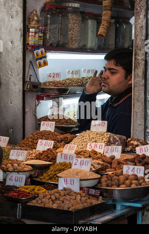 New Delhi, India. Vendor of Nuts and Dried Figs in his Shop. Stock Photo