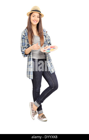 Full length portrait of a female painter leaning against a wall Stock Photo