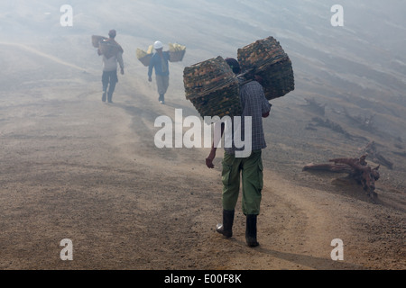 Men with baskets used for transportation of sulfur blocks, Kawah Ijen, Banyuwangi Regency, East Java, Indonesia Stock Photo