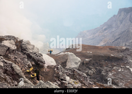 Men with baskets laden with blocks of sulfur, Kawah Ijen, Banyuwangi Regency, East Java, Indonesia Stock Photo