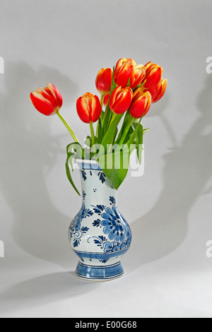 Red and yellow Dutch tulips in a blue and white Dutch Delft China vase Stock Photo