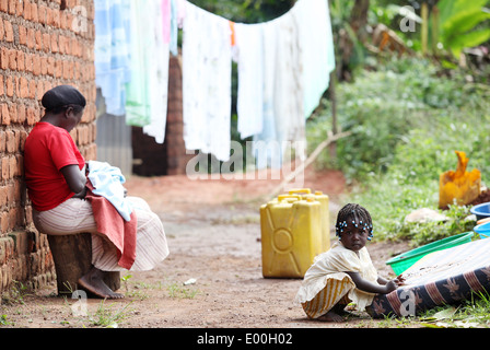 A mother and child outside their home in the Mawale area of the Luwero district in central Uganda. Stock Photo