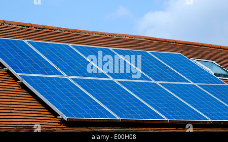 Solar energy panels on a slanting roof England UK Stock Photo