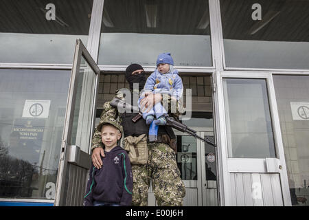 Kostantinovka, Donestsk, Ukraine. 28th Apr, 2014. Pro-Russian armed men pose for a photograph with a child as they stand guard outside a regional administration building seized in the night by pro-Russian separatists, in the eastern Ukrainian city of Kostyantynivka, on April 28, 2014. Kostyantynivka has 80,000 inhabitants and is located mid-way between the flashpoint town of Slavyansk and the regional hub city of Donetsk, both of which are also under the control of insurgents. Stock Photo