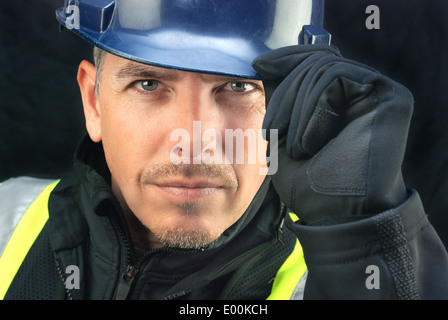 Close-up of a construction worker putting on his hardhat. Stock Photo