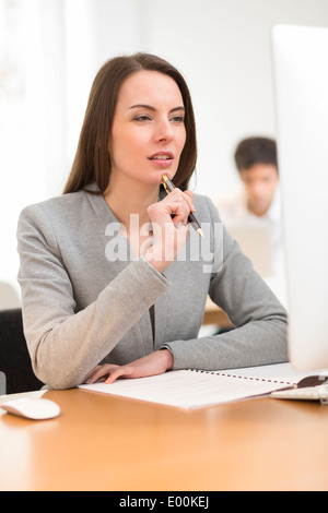 Pretty woman desk computer background colleague Stock Photo