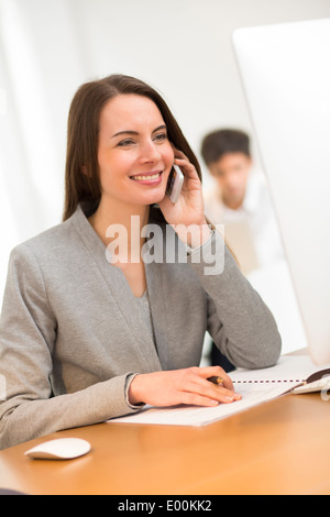smiling Female pretty smartphone desk computer Stock Photo