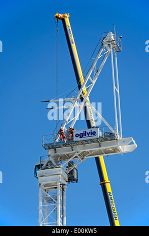 Two construction workers taking a break and admiring the view from a crane in Edinburgh. Stock Photo