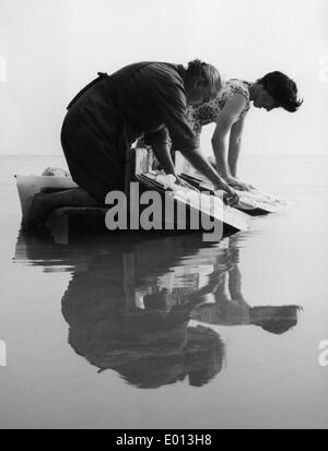 Doing the laundry in the 1960s. A lady is using a washboard to clean the  dirty laundry. The tool was designed for hand washing clothing rubbing them  agains the series of ridges