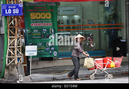 A woman street trader pushes a trolley in central Hanoi, capital of Vietnam Stock Photo