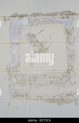 An ivory, vanilla colored grid wall with paper and glue residues. An artistic abstract background. Stock Photo