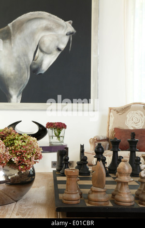 Close-up of hydrangeas and giant chess set with horse painting in background, Belleview Villa, St Tropez. Stock Photo