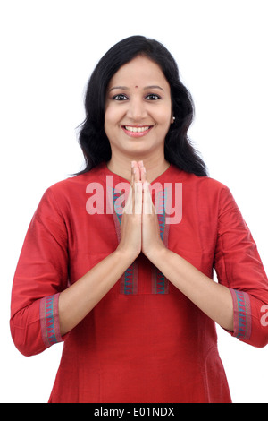 Smiling young woman greeting 'Namasthe' against white background Stock Photo