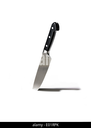 Kitchen knife stuck in white background with shadow Stock Photo