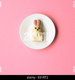 White chocolate bunny rabbit on a white plate, pick background Stock Photo