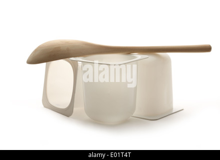 Empty plastic yogurt pots with wooden spoon Stock Photo