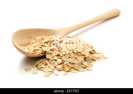 Heap of rolled oats with wooden spoon on white Stock Photo