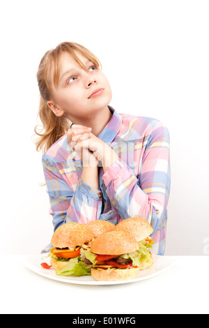 Little blond girl with big homemade hamburgers on white plate Stock Photo