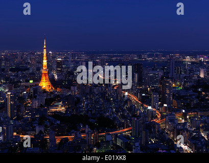 Tokyo Tower and brightly lit highways in city landscape at nighttime, aerial view. Tokyo, Japan. Stock Photo