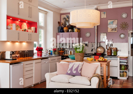 TMO geometric pendant light in kitchen with small sofa. Back wall is painted in Dirty Lilac from Rose of Jericho Stock Photo