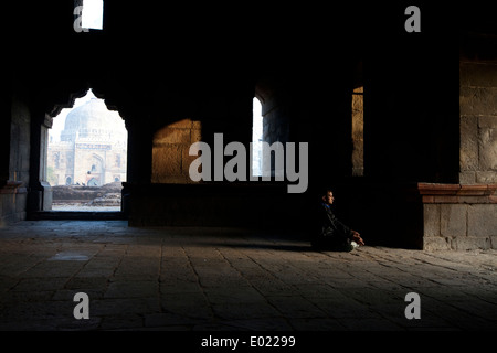 A man meditates at dawn in the Bara Gumbad tomb in Lodi Gardens, New Delhi, India, Stock Photo