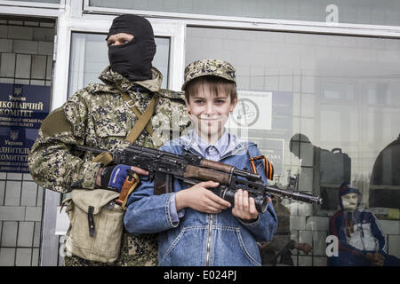 Konstantinovka, Donetsk, Ukraine. 28th Apr, 2014. Pro-Russian armed men pose for a photograph with a boy as they stand guard outside a regional administration building seized in the night by pro-Russian separatists. United States moved to impose fresh sanctions against Russia today over the crisis in Ukraine. © Sandro Maddalena/NurPhoto/ZUMAPRESS.com/Alamy Live News Stock Photo