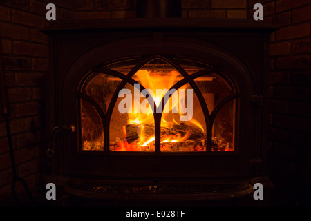 Fire burning in a wood stove at a lodge cabin. Stock Photo