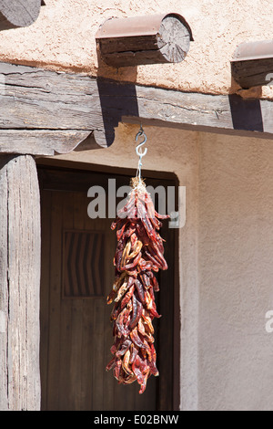 Ristra of dried chili peppers hanging in New Mexican doorway Stock Photo