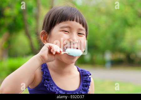 happy little girl eating popsicle at summertime Stock Photo