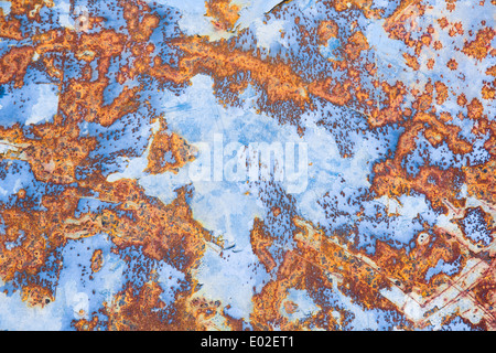A rusty old metal plate with cracked blue gloss paint. Stock Photo