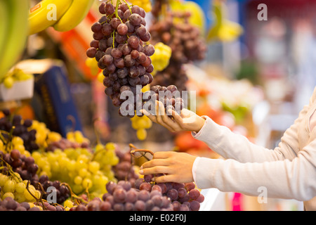 Female close-up hand banana orange grape Stock Photo