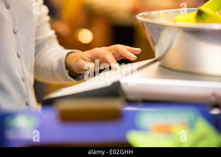 Female young close-up hand fruit bill scales Stock Photo