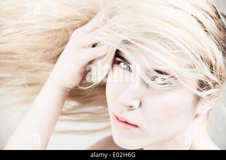 Young beautiful blonde woman with long hair. Showing expression of cool attitude and personality. Stock Photo